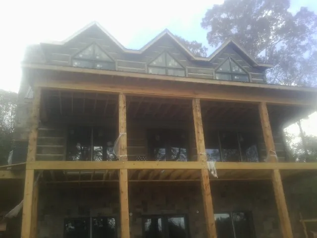 Dormers and porch framing on a large log home under construction — Roof Coating work by our crew in Clatskanie