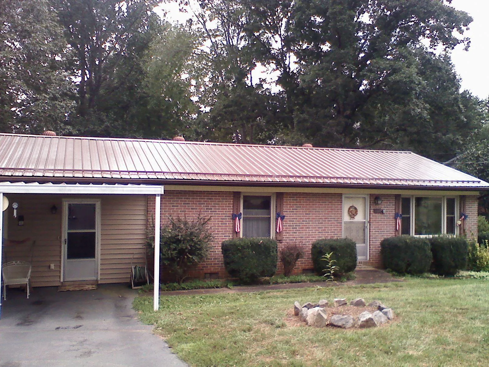 Bronze metal roof and carport on a brick ranch home — Roof Repair work by our crew in Clatskanie